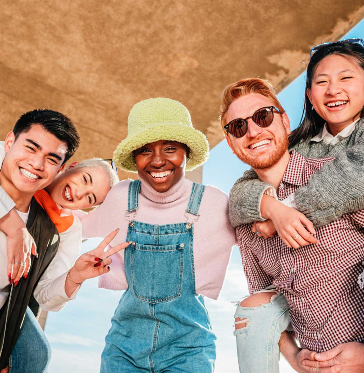 A diverse group of smiling young adults gathered together